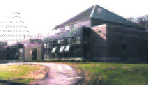 heath (2) A large brick building with a sloped roof, multiple windows, and a curved driveway in front.