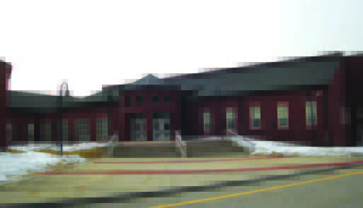 ipswich (1) A red brick building with an entrance ramp and stairs, bordered by patches of melting snow.