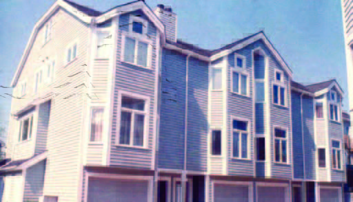 rollins (1) A row of modern, three-story townhouses with light blue siding and multiple large windows under a clear sky.