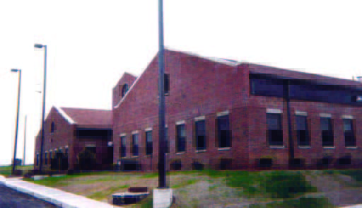 westover (1) A large, two-story red brick building with multiple windows and a sloped roof, set on a grassy lot.